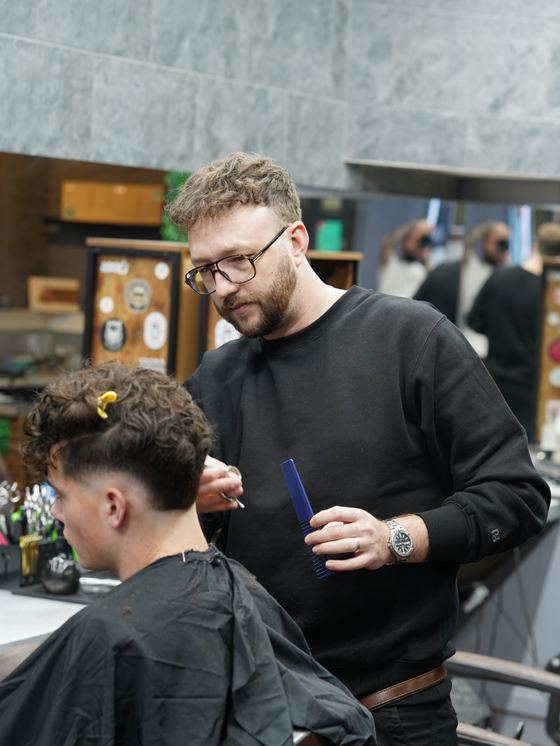 Daniel cutting a curly-haired client at Evoke Barbers, Nottingham