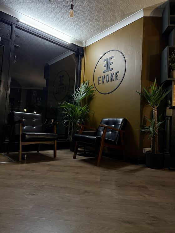 Inside Evoke Barbers in the evening: the waiting area at 10 Flying Horse Walk