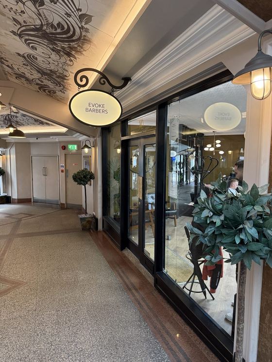 The Evoke Barbers shop front and hanging sign inside Flying Horse Walk arcade, Nottingham