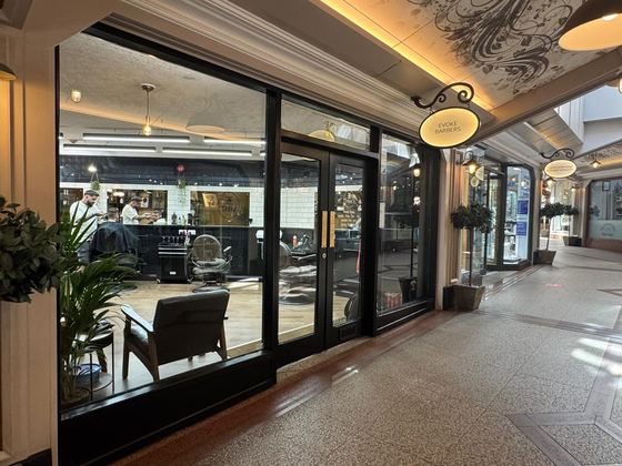 The Evoke Barbers window in Flying Horse Walk, with barbers at work inside