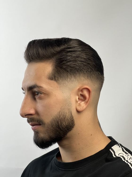 A neat side part with a low fade and tidy beard at Evoke Barbers, Nottingham